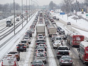 Queensway traffic as seen from the Greenbank overpass looking east is slowed to a crawl in the morning commute as an overnight snowfall caused a number of hazards.