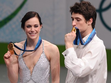 Canada's Tessa Virtue and Scott Moir display their gold medals on the podium after winning the 2010 Winter Olympics ice dance figure skating competition at the Pacific Coliseum in Vancouver on February 22, 2010.             AFP PHOTO/Saeed KHAN