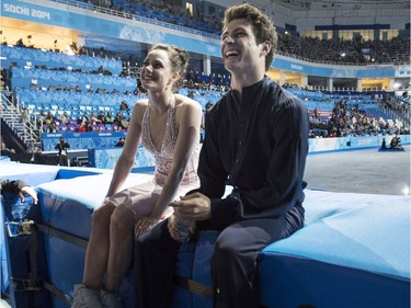 Ice dance silver medallists Canada's Tessa Virtue and Scott Moir sit on the boards as they wait for the start of the flowers ceremony at the Sochi Winter Olympics Monday, February 17, 2014 in Sochi.