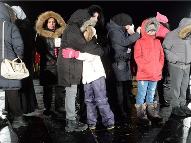 Family members of victims stand on stage as they attend a vigil to commemorate the one-year anniversary of the Quebec City mosque shooting, in Quebec City, Monday, Jan. 29, 2018.