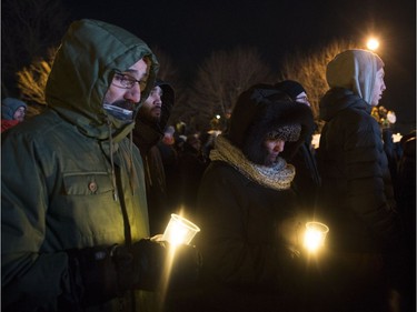 People hold candles at a vigil to commemorate the one-year anniversary of the Quebec City mosque shooting, in Quebec City, Monday, Jan. 29, 2018.