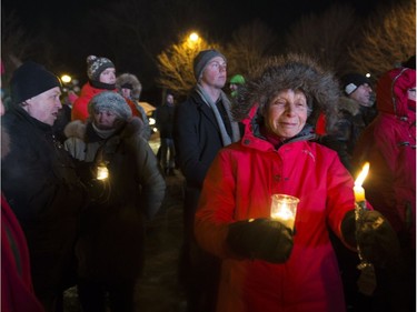 People hold candles at a vigil to commemorate the one-year anniversary of the Quebec City mosque shooting, in Quebec City, Monday, Jan. 29, 2018.