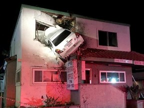 A car hit a centre divider, went airborne and crashed into the second floor of a small office building in Santa Ana, Calif., on Sunday.