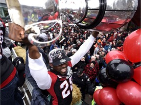 Ottawa Redblacks Nick Taylor raises the Grey Cup over his head as he rides on a float at a parade celebrating the team's victory over the Calgary Stampeders, Tuesday, Nov. 29, 2016 in Ottawa.