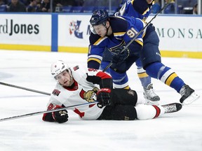 Senators winger Bobby Ryan, bottom, reaches for a puck after being knocked to the ice by the Blues' Vladimir Tarasenko during Tuesday's game at St. Louis.