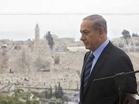 In this Monday, Feb. 23, 2015 file photo Israeli Prime Minister Benjamin Netanyahu walks past a window overlooking the Old City of Jerusalem.