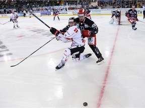 Chris Kelly, left, battles for the puck with Mountfield's Oskars Cibulskis during Canada's Spengler Cup game in Davos on Dec. 26. Melanie Duchene/Keystone via AP