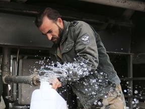 In this Monday, Jan. 16, 2017 photo, man fills a plastic container with water from a tap water in Damascus, Syria. Water cut-offs have been almost continuous since Dec. 22, in the worst water crisis known to Damascus residents. It comes at a time when the country is suffering electricity cuts and lack of other services as Syria's conflict approaches its seventth year in March.