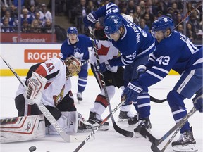 Toronto Maple Leafs left wing James van Riemsdyk (25) and Toronto Maple Leafs center Nazem Kadri (43) can't get the bouncing puck past Ottawa Senators goaltender Craig Anderson (41), as the Toronto Maple Leafs take on the Ottawa Senators at the Air Canada Centre in Toronto on Thursday January 11, 2018. Stan Behal/Toronto Sun/Postmedia Network