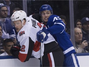 Senators defenceman Dion Phaneuf (2) gets tied up by Maple Leafs centre Tyler Bozak in the first period of Wednesday's game in Toronto. Stan Behal/Postmedia