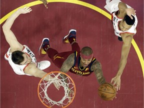 Cleveland Cavaliers' Isaiah Thomas, center, drives to the basket against Portland Trail Blazers' Pat Connaughton, left, and CJ McCollum in the second half of an NBA basketball game, Tuesday, Jan. 2, 2018, in Cleveland. The Cavaliers won 127-110.