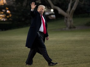 President Donald Trump waves as he walks on the South Lawn upon his return to the White House in Washington, Thursday, Dec. 21, 2017, from a visit to Walter Reed National Military Medical Center in Bethesda, Md.