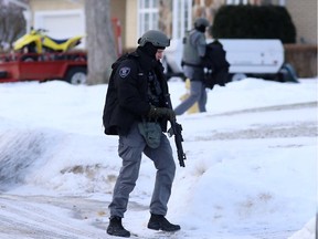 Kingston police officers walk along Glen Cairn Terrace in Kingston's west end while trying to arrest a suspect in Kingston, Ont. on Wednesday, Jan. 24, 2018.