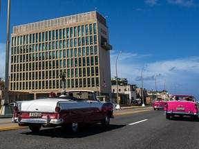 Tourists ride in classic cars on the Malecon beside the U.S. Embassy in Havana, Cuba, on Oct. 3, 2017.