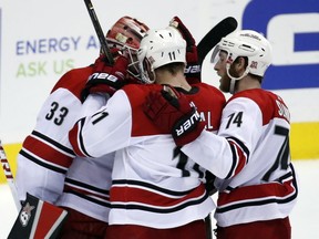 Carolina Hurricanes goalie Scott Darling (33), center Jordan Staal (11), and defenseman Jaccob Slavin (74) celebrate after an NHL hockey game against the Washington Capitals, Thursday, Jan. 11, 2018, in Washington.