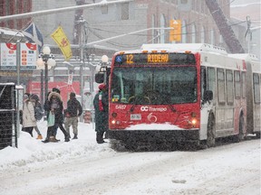 An OC Transpo bus on Rideau St as the region experiences continuing snowfall on Monday.