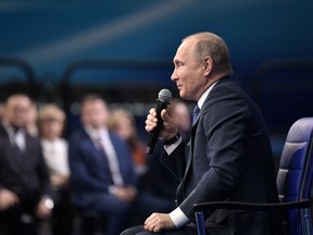 Russian President Vladimir Putin speaks to his supporters during a meeting for his campaign in Moscow, Russia, Tuesday, Jan. 30, 2018. Putin said on Tuesday the Trump administration made a "hostile step" when it published a list of Russian businessmen and politicians as part of a sanctions law against Moscow.