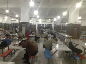 In this photo taken in Oct. 2017 and provided to the Associated Press by China Labor Watch, workers rest at night in a cafeteria at a Catcher Technologies factory in Suqian in eastern China's Jiangsu province. An Apple Inc. supplier in eastern China on Wednesday denied allegations by a New York rights group that its workers toil for ten-hour shifts in loud, polluted conditions, without proper overtime pay or adequate safety protections to make MacBook and iPhone parts, before returning to filthy dormitories with cold showers. Apple also said it sent an investigative team to Suqian to interview over 150 workers but "found no evidence that Catcher was violating our standards." (China Labor Watch via AP)