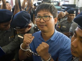 Reuters journalist Thet Oo Maung Maung, known as Wa Lone, is escorted by police upon arrival at court Wednesday, Jan. 10, 2018, outside Yangon, Myanmar.