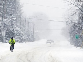 A cyclist makes his way through the deep snow Ottawa was blanketed with on Sunday Feb. 4, 2018.