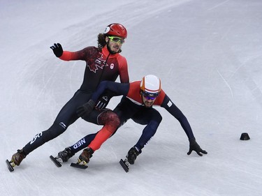 Canada's Samuel Girard falls and Netherlands' Sjinkie Knegt compete in the men's 5,000m relay short track speed skating heat event during the Pyeongchang 2018 Winter Olympic Games, at the Gangneung Ice Arena in Gangneung on February 13, 2018.