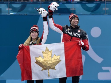 Canada's Kaitlyn Lawes and Canada's John Morris celebrate on the podium during the venue ceremony after winning the curling mixed doubles gold medal game against Switzerland during the Pyeongchang 2018 Winter Olympic Games at the Gangneung Curling Centre in Gangneung on February 13, 2018.
