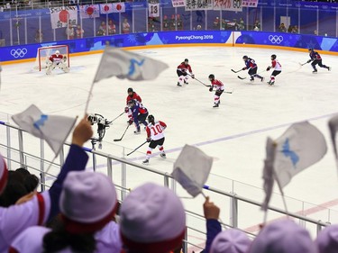 North Korean cheerleaders wave the Korean unification flags and cheer during the women's preliminary round ice hockey match between Japan and the Unified Korean team during the Pyeongchang 2018 Winter Olympic Games at the Kwandong Hockey Centre in Gangneung on February 14, 2018.