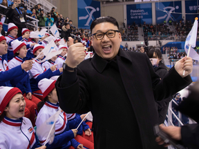 A man impersonating North Korean leader Kim Jong Un gestures as he stands before North Korean cheerleaders attending the Unified Korean ice hockey game against Japan.