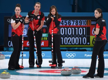Canada's Joanne Courtney (L), Emma Miskew (2nd L), Rachel Homan and Lisa Weagle (R) watch during the curling women's round robin session between Canada and Sweden during the Pyeongchang 2018 Winter Olympic Games at the Gangneung Curling Centre in Gangneung on February 15, 2018.