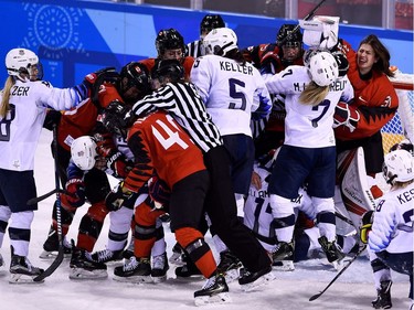 Players pile up on the Canadian goal in the women's preliminary round ice hockey match between the US and Canada during the Pyeongchang 2018 Winter Olympic Games at the Kwandong Hockey Centre in Gangneung on February 15, 2018.