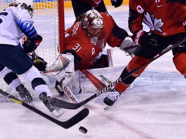 Canada's Genevieve Lacasse (C) defends her goal in the women's preliminary round ice hockey match between the US and Canada during the Pyeongchang 2018 Winter Olympic Games at the Kwandong Hockey Centre in Gangneung on February 15, 2018.