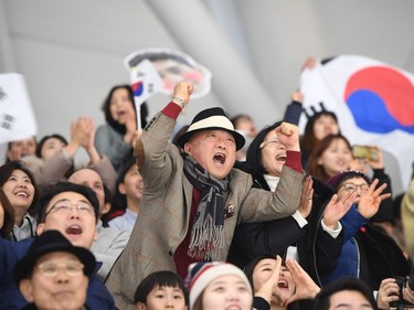 South Korean fans cheer on South Korea's Lee Seung-Hoon competing in the men's 10,000m speed skating event during the Pyeongchang 2018 Winter Olympic Games at the Gangneung Oval in Gangneung on February 15, 2018.