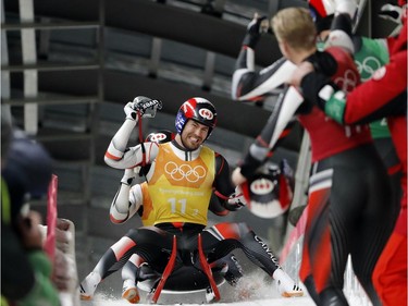 Alex Gough, in red, Sam Edney, in green, Tristan Walker and Justin Snith of Canada react in the finish area after Canada won the silver medal in the luge team relay at the 2018 Winter Olympics in Pyeongchang, South Korea, Thursday, Feb. 15, 2018.