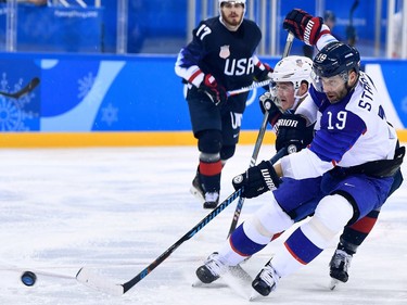 USA's Chris Bourque (L) watches as USA's Ryan Donato and Slovakia's Tomas Starosta (R) fight for the puck in the men's preliminary round ice hockey match between the US and Slovakia during the Pyeongchang 2018 Winter Olympic Games at the Gangneung Hockey Centre in Gangneung on February 16, 2018.