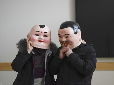 Some volunteers try on the masks prior to Chinese New Year celebration at Plant recreation centre on Saturday, Feb. 17, 2018.