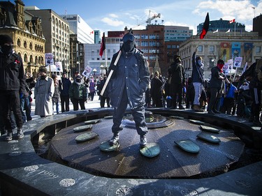 An anti-racist protestor stands in the Centennial Flame. 

Ashley Fraser/Postmedia