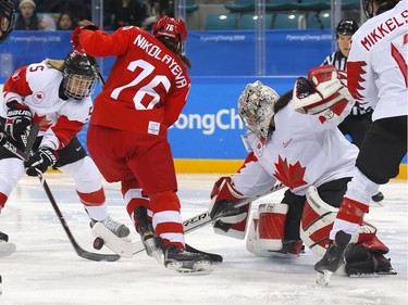 Olympic Athlete from Russia defenceman Yekaterina Nikolayeva, middle, tries to score on Canada goaltender Shannon Szabados during their game in Gangneung, South Korea, at the 2018 Winter Olympics on Monday, Feb. 19, 2018. Leah Hennel/Postmedia\