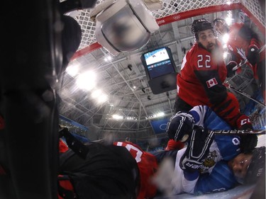 Canada's Eric O'Dell (top) falls onton Finland's Veli-Matti Savinainen (R) as he hits Canada's Ben Scrivens (L) in the men's quarter-final ice hockey match between Finland and Canada during the Pyeongchang 2018 Winter Olympic Games at the Gangneung Hockey Centre in Gangneung on February 21, 2018.