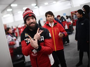 Olympic short track bronze medallist Charles Hamelin makes victory signs backstage at the Athletes' Lounge during the medal ceremonies at Pyeongchang on Feb. 23.