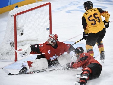 Canada's Kevin Poulin (L) looks on as a goal is scored in the men's semi-final ice hockey match between Canada and Germany during the Pyeongchang 2018 Winter Olympic Games at the Gangneung Hockey Centre in Gangneung on February 23, 2018.