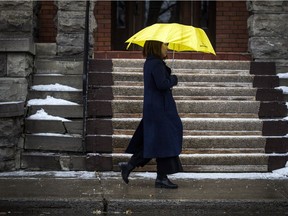 A woman walks along Elgin Street as Ottawa was hit with freezing rain Sunday Feb. 25, 2018.