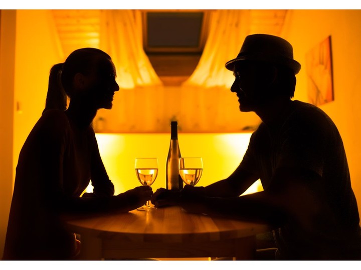  Young couple enjoying conversation and a glass of wine.