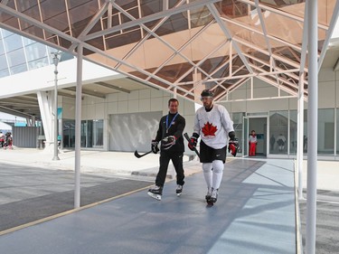 Former Ottawa Senators player Chris Kelly, right, named captain of the Canadian Olympic men's hockey team earlier this week, walks to practice with assistant coach Scott Walker in Pyeongchang, South Korea, on Friday.