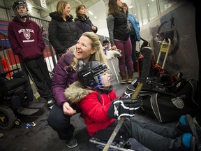 Emily Glossop, a recreation therapist at Ottawa Children's Treatment Centre, chats with six-year-old Danielle Cloutier before she hits the ice to give sledge hockey a try at Jim Durrell Recreation Centre.