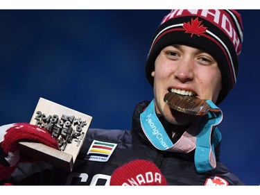 Canada's bronze medallist Alex Beaulieu-Marchand bites his medal on the podium during the medal ceremony for the freestyle skiing men's ski slopestyle at the Pyeongchang Medals Plaza during the Pyeongchang 2018 Winter Olympic Games in Pyeongchang on February 18, 2018.