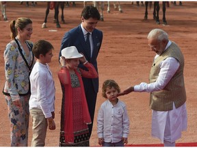 Indian Prime Minister Narendra Modi (R) touches the cheek of Hadrien Trudeau, the youngest son of Prime Minister Justin Trudeau and his wife, Sophie Grégoire Trudeau, as their other children, Ella-Grace, and Xavier look on, while attending a ceremonial reception at the Presidential Palace in New Delhi Friday.