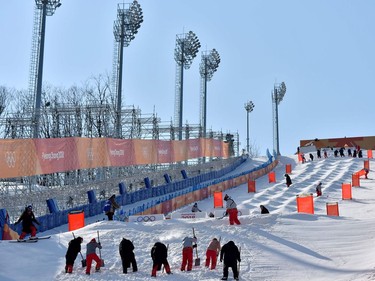 Volunteers prepare the slope during a moguls training session on the eve of the Pyeongchang 2018 Winter Olympic Games at the Phoenix Park in Pyeongchang on February 8, 2018.