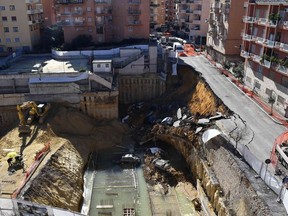 The picture taken on February 15, 2018 in the street of Balduina's district in Rome shows a general view of a huge sinkhole that opened up the day before in Rome, swallowing six cars. No casualties were reported. About 22 families were evacuated by firefighters following the collapse. The cause of the sinkhole is still under investigation.