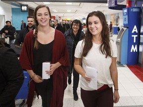 Ottawa's Jessica Drolet, left, and Eden Kazoleas of Alberta smile after arriving at Toronto Pearson International Airport on Friday evening. They returned to Canada after being arrested in Cambodia on Jan. 25.