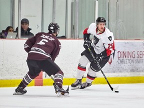 Carleton's Alexandre Boivin skates the puck up ice while uOttawa's Matt Dunlop defends. Ontario University Athletics Men's Playoff Hockey game between the Ottawa Gee-Gees and the Carleton Ravens held on Feb 14, 2018 at the Ice House at Carleton University.